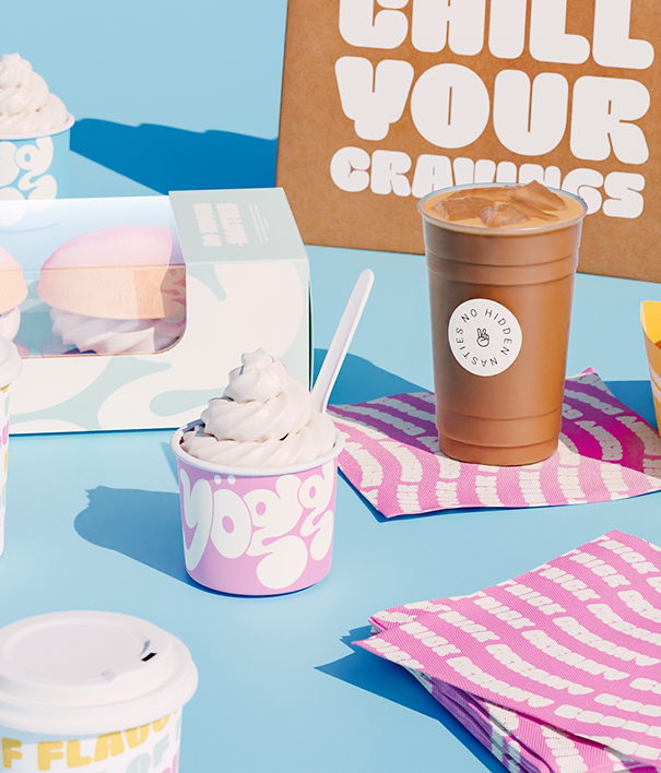 Playful branded frozen yogurt cups, cold coffee and packaging on a bright blue surface